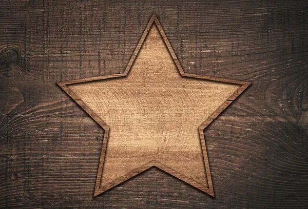 Hnědá dřevěná hvězda s rámečkem na temné desce — Stock fotografie