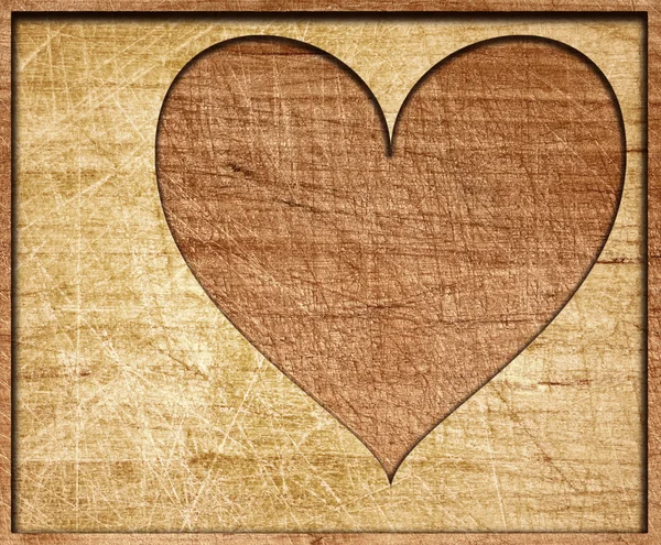 Heart shape cut on wooden board with frame — Stock Photo, Image