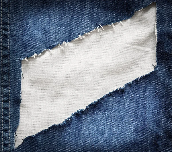 Texture en tissu blanc avec un jean bleu déchiré — Photo