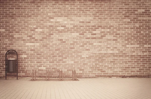 Backstein Grunge verwitterten braunen Wand Hintergrund mit Gehweg und Mülleimer — Stockfoto