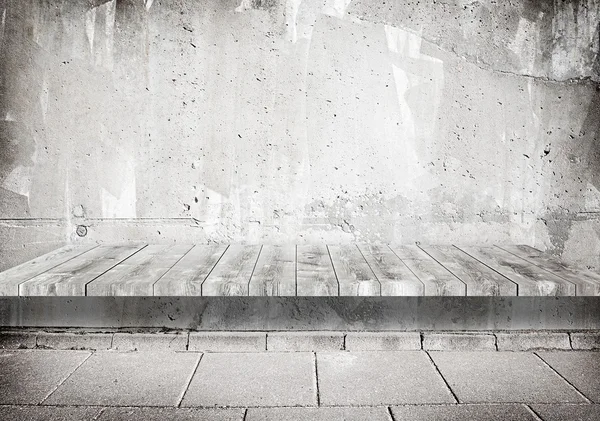 Mur gris grunge en béton avec étagère en bois, surface de la table et allée en tuiles — Photo