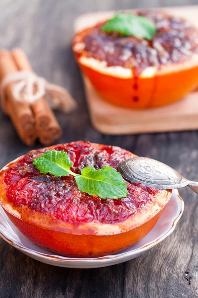 Печеный грейпфрут с коричневым сахаром и корицей на блюдце — стоковое фото