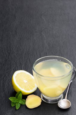 Siyah taş zemin üzerinde zencefil kökü olan çay 