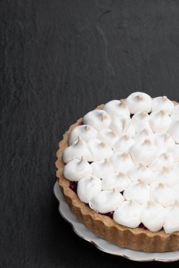 Siyah taş arka planda kremalı turta. 