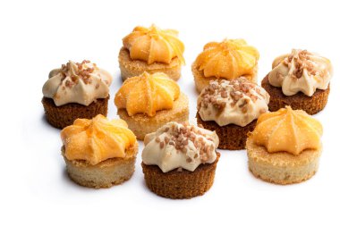 Portakal ve karamel kremalı mini sünger kekleri beyaz üzerine izole edilmiş. 