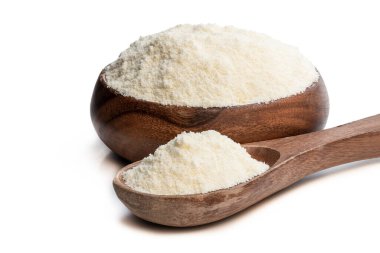 Tam yağlı süt tozu beyaz kaşıkta izole edilmiş. 