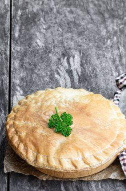 Taş ahşap kırsal masada etli börek. 