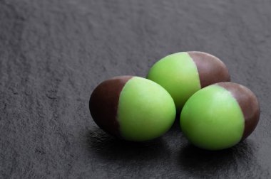 Naneli sütlü çikolatalı mini yumurta, siyah taşlı arka plan. 