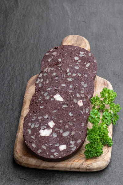 Traditional  black pudding sausage slices on black stone background