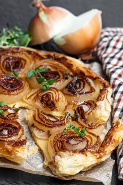 Yapışkan karamelli soğanlı tart siyah taşlı arka planda 