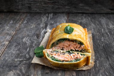 Ev yapımı somon Wellington, ıspanak ve mantarlı, ahşap masa. 