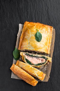 Ev yapımı somon Wellington, ıspanak ve mantarlı, ahşap masa. 