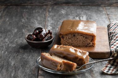 Yapış yapış puding tereyağlı sünger ve ahşap masa üzerinde hurma. 