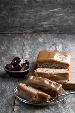 Yapış yapış puding tereyağlı sünger ve ahşap masa üzerinde hurma. 