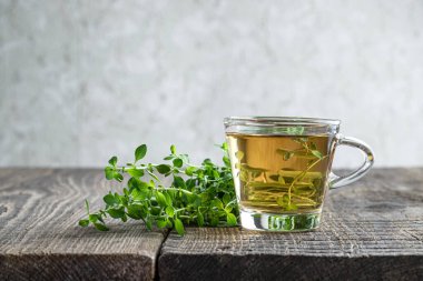 Yeşil çay ve limon merhemi, cam bardakta kırsal ahşap masada. 