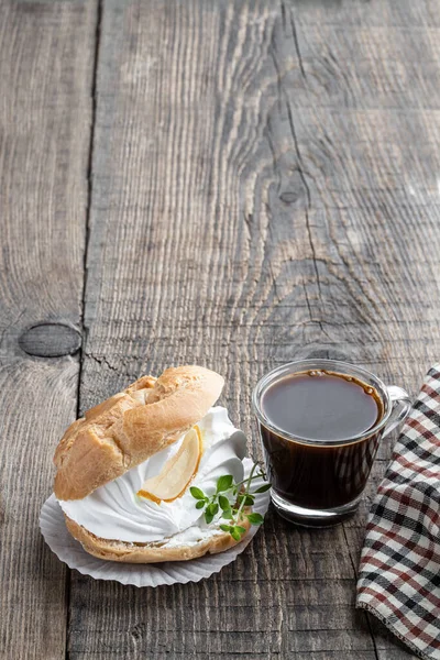 レモンバームハーブとコーヒーカップと素朴な木製のテーブルの上にホイップクリームとシューケーキのプロフィテロール — ストック写真