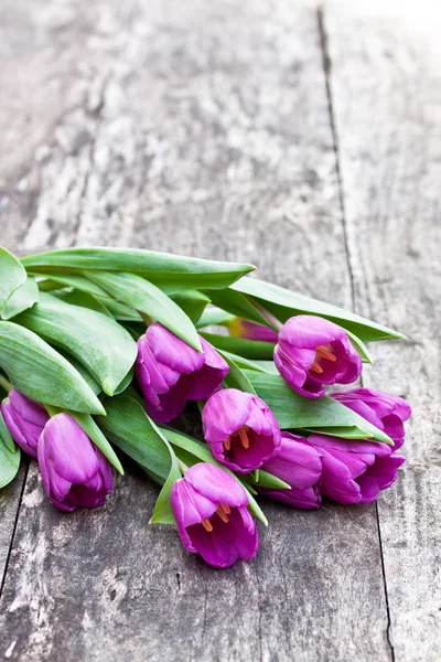 Boeket van violet tulpen op eiken bruin tafel — Stockfoto