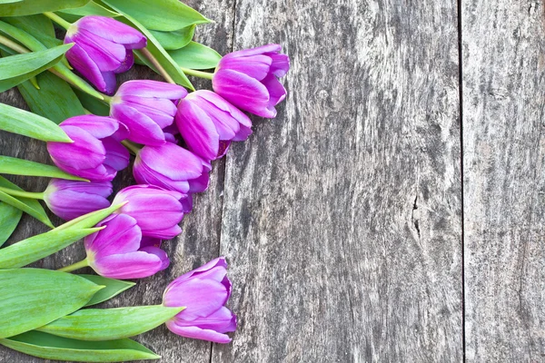 Boeket van violet tulpen op eiken bruin tafel — Stockfoto