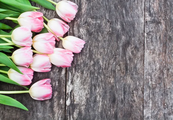 Lichte roze tulpen op eiken bruin tafel met wit vel pap — Stockfoto