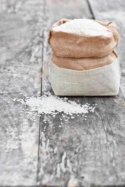 Bolsa de arroz en la mesa de roble marrón — Foto de Stock