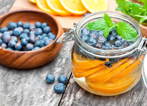 Homemade fruit drink with berries oranges and mint — Stock Photo, Image