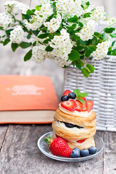 Puff pastry with berries old book and beautiful bouquet of white — Stock Photo, Image
