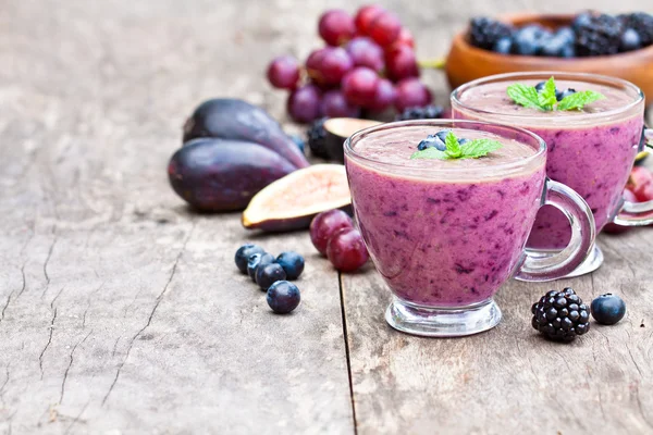与紫色的水果和浆果的新鲜健康得稀烂鸡尾酒 — 图库照片