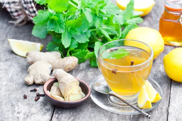 Травяной чай с лимоном и имбирем на деревянном столе — стоковое фото