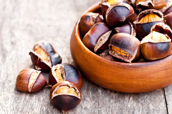 Roasted chestnuts on wooden background — Stock Photo, Image