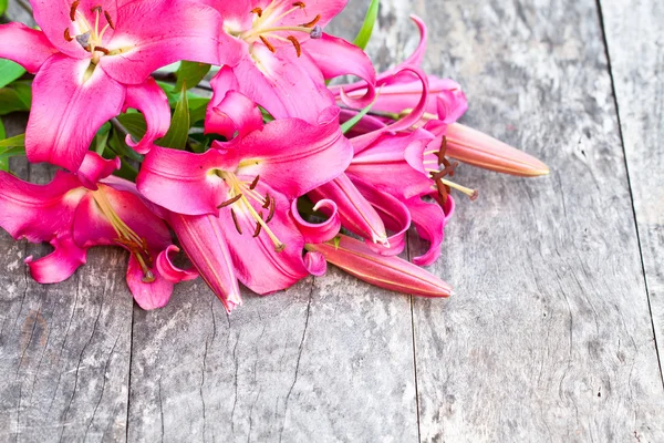 Pink lily Robina flowers bouquet on rustic wooden table — Stock Photo, Image