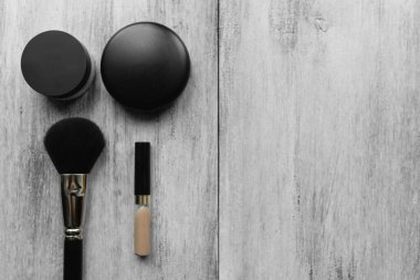 Makyaj fırçaları ve hafif ahşap zemin üzerindeki toz.