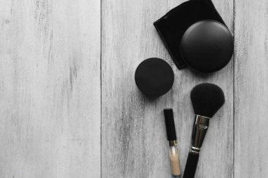 Makyaj fırçaları ve hafif ahşap zemin üzerindeki toz.