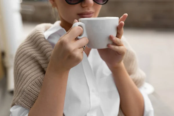 Hermosa chica en un café de la calle bebe café —  Fotos de Stock