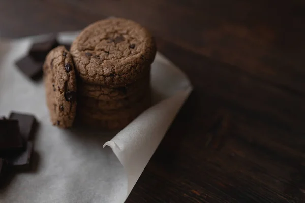 Galletas de avena y trozos de chocolate sobre fondo de madera oscura — Foto de Stock