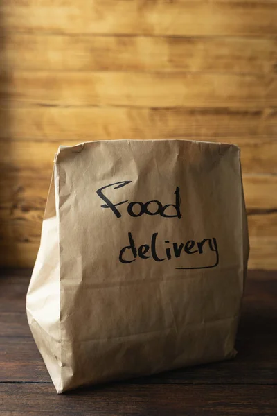 Craft package with food delivery on dark wooden background — Stock Photo, Image