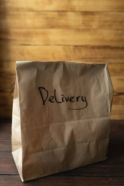 Pacote de artesanato com entrega de alimentos em fundo de madeira escura — Fotografia de Stock