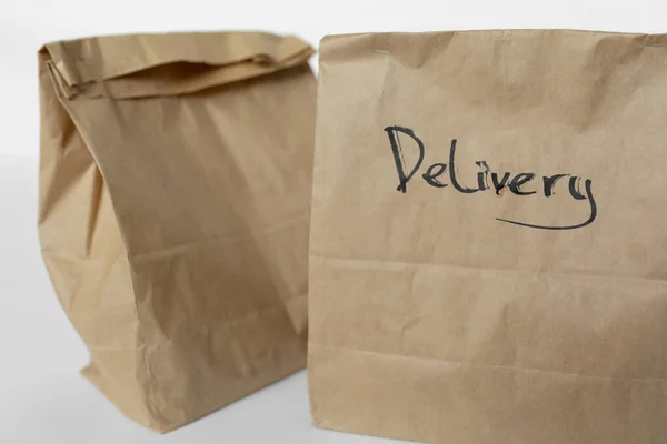 Basteltaschen mit Essenslieferung auf weißem Hintergrund — Stockfoto