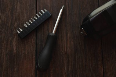 Koyu ahşap arka planda tornavida ve elektronik aygıt