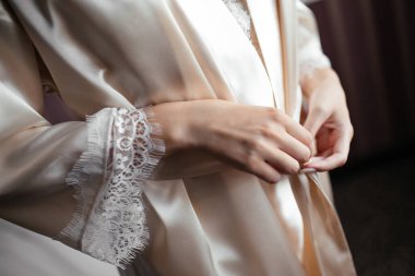 Kız pijama cüppesinin kemerini düzeltiyor.