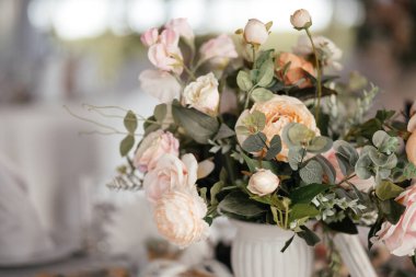 Düğün çiçeği aranjmanı beyaz masada.