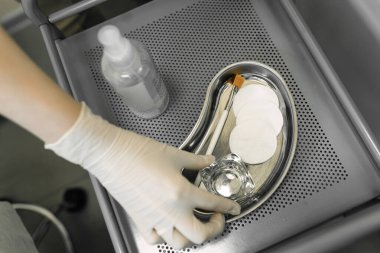 Güzellik uzmanı işlemler için aletleri hazırlar.