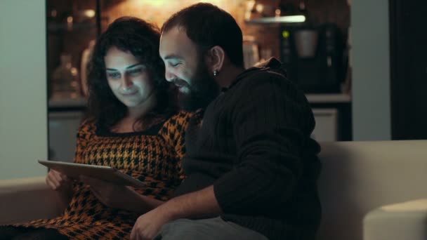 Para przy użyciu tabletu na kanapie w nocy w pokoju — Wideo stockowe