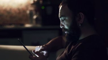 Genç adam karanlıkta onun tablet okuma