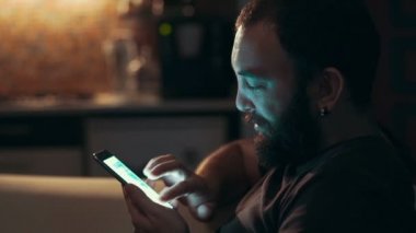 Karanlıkta onun akıllı telefon kullanan genç adam