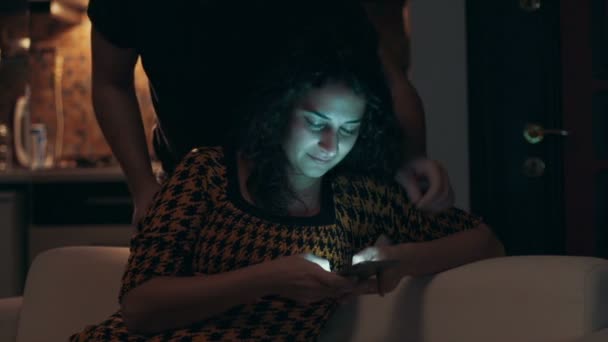 Пара с помощью планшета на диване ночью в номере — стоковое видео