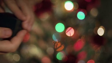 Eller yukarı nişan yüzüğü teklif yakın. Garland yanıp sönüyor. Noel ağacı arka plan