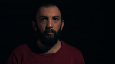 Adam kızgın bir yüz siyah bir arka plan üzerinde yapar.