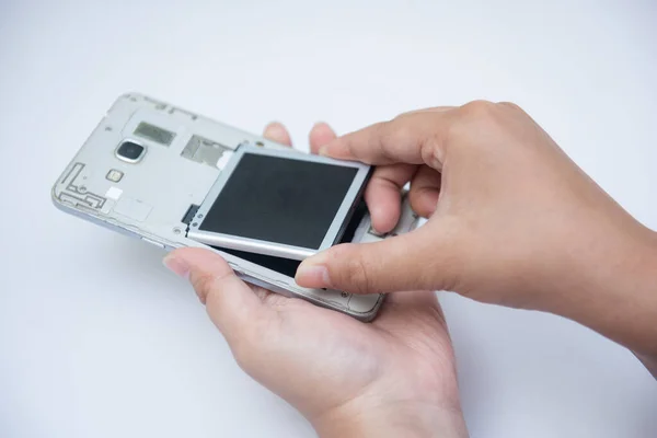 Hand of  technician or engineer turns on the smartphone to replace the end-of-life battery