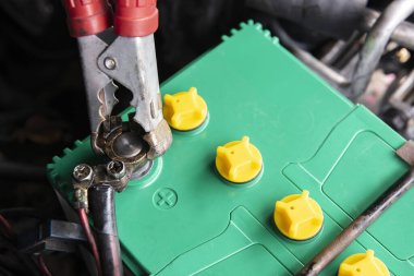 Araç aküsünü, doğru terminal ve zemin kablosunu yerleştirerek elektrik hatlarıyla şarj ediyorum.