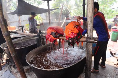 Bangladeşli işçiler 26 Nisan 2018 'de Bangladeş' in Dhaka yakınlarındaki Narsingdi bölgesinde Batik Kumaş endüstrisinde çalışmaktadır. Her işçi 400-500 Taka ya da 5-6 Amerikan Doları kazanır..
